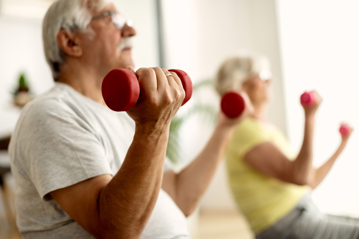 closeup-senior-couple-exercising-with-dumbbells-home